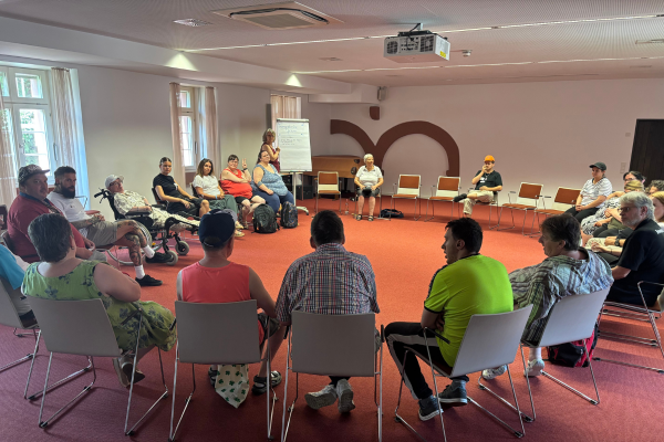 Menschen sitzen in einem Stuhlkreis bei einem Workshop