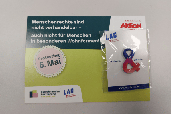 Eine Postkarte mit einer aufgeklebten Inklusionsschleife.