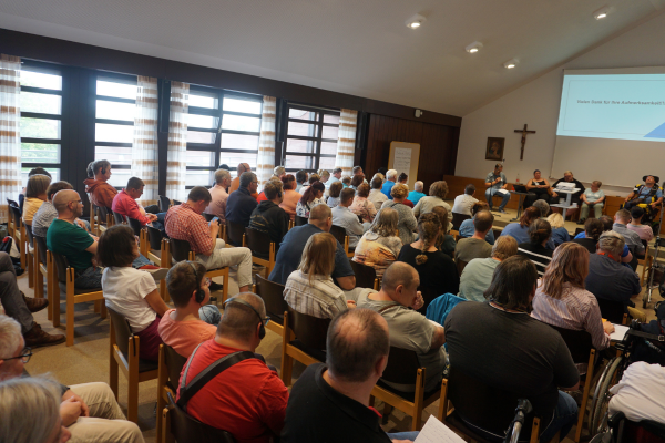 Viele Menschen von hinten in einem Konferenzraum