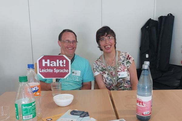 Zwei Teilnehmende halten ein Schuld 