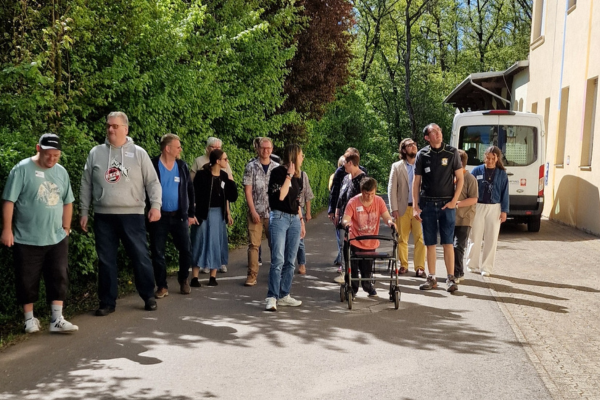 Mehrere Menschen draußen, die einen Rundgang über das Gelände machen